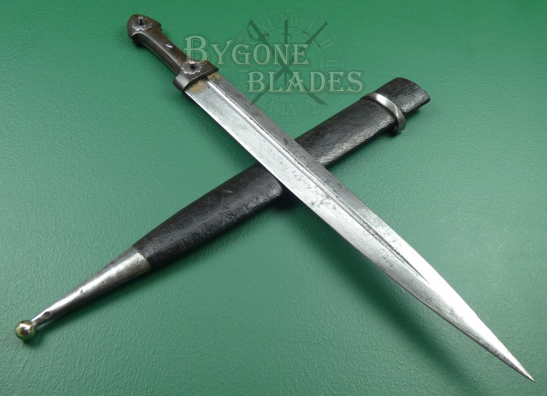 Caucasian qama or kindjal dagger, the 15cm pointed double edged blade with centre fuller and two-piece horn grip; in nickel plated scabbard with panels of figures and script L28.5cm overall; and east